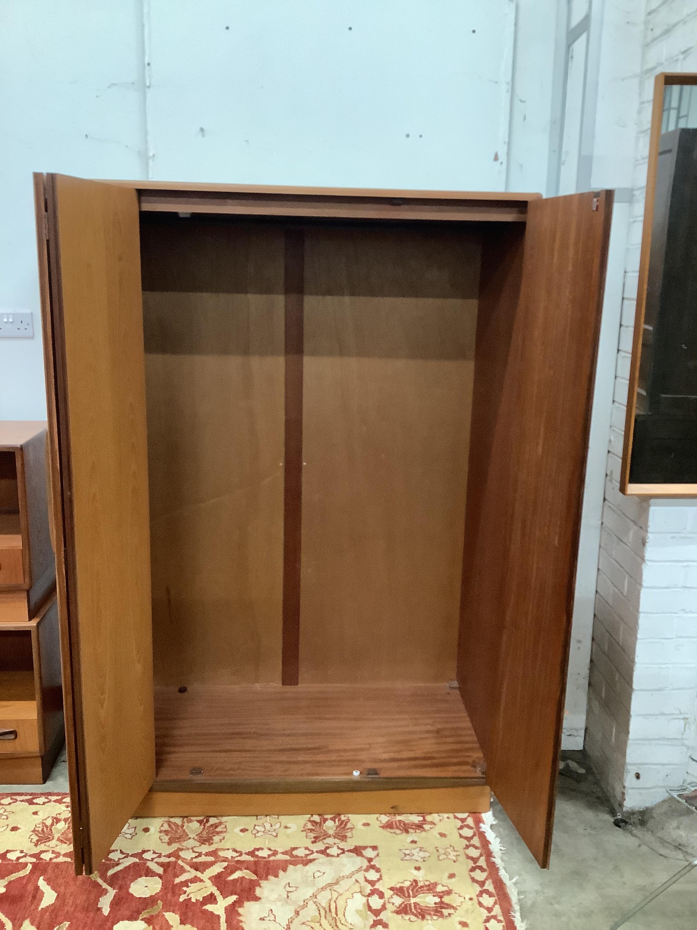 A mid century G Plan Fresco teak triple wardrobe, width 120cm, depth 58cm, height 176cm together with a pair of G Plan teak bedside cabinets